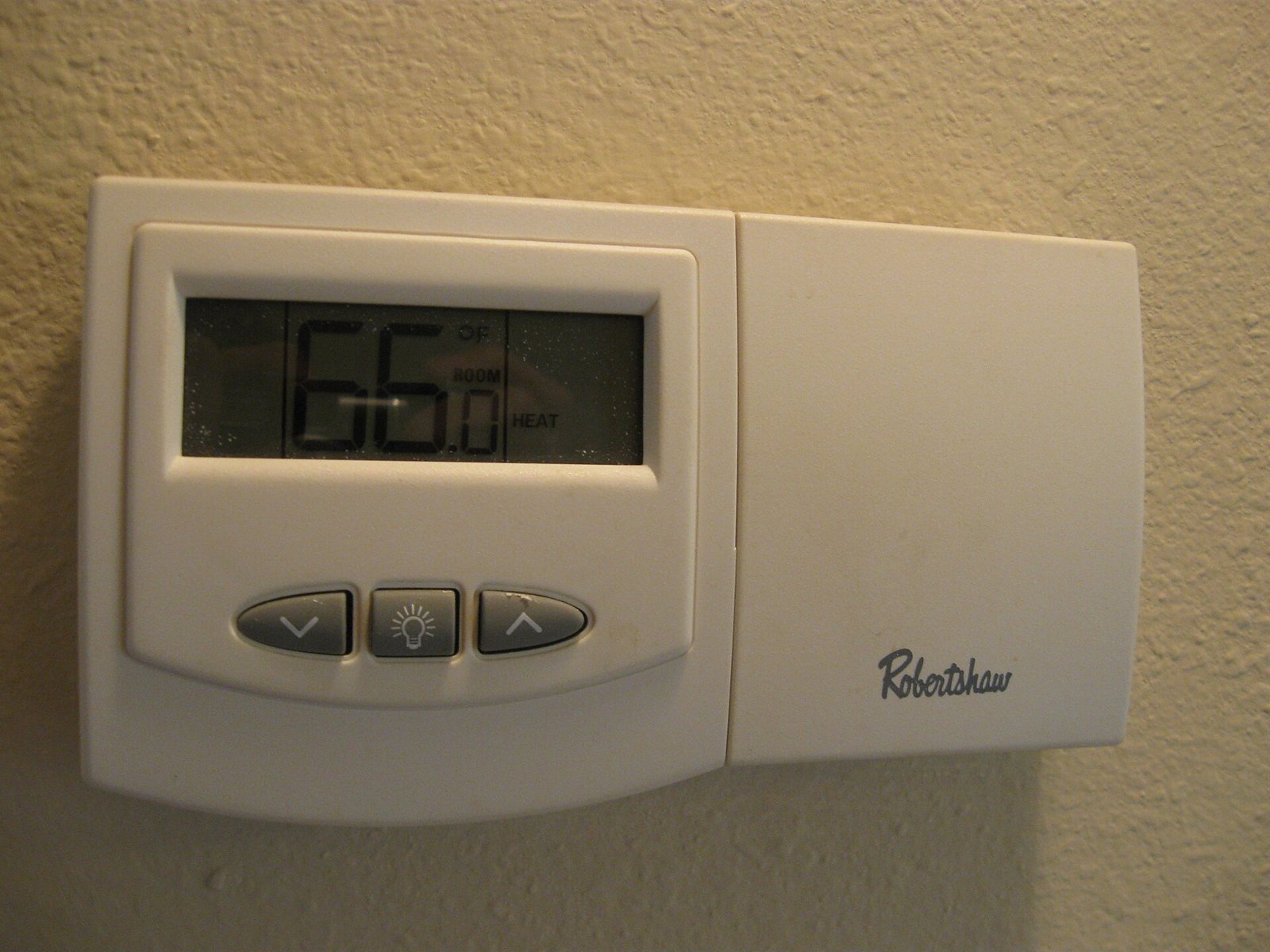 Thermostat d'ambiance numérique fixé sur un mur intérieur