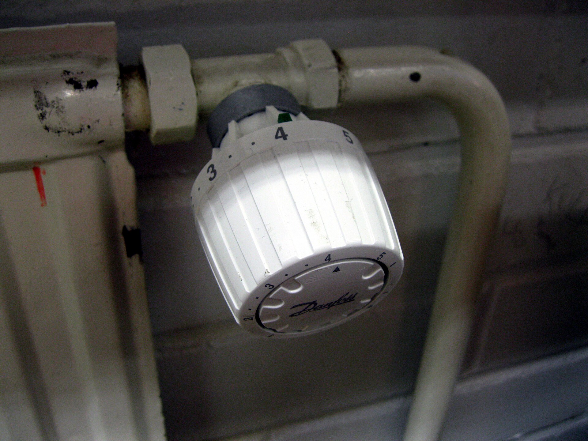 Tête thermostatique blanche graduée de 1 à 5 vissée sur un radiateur