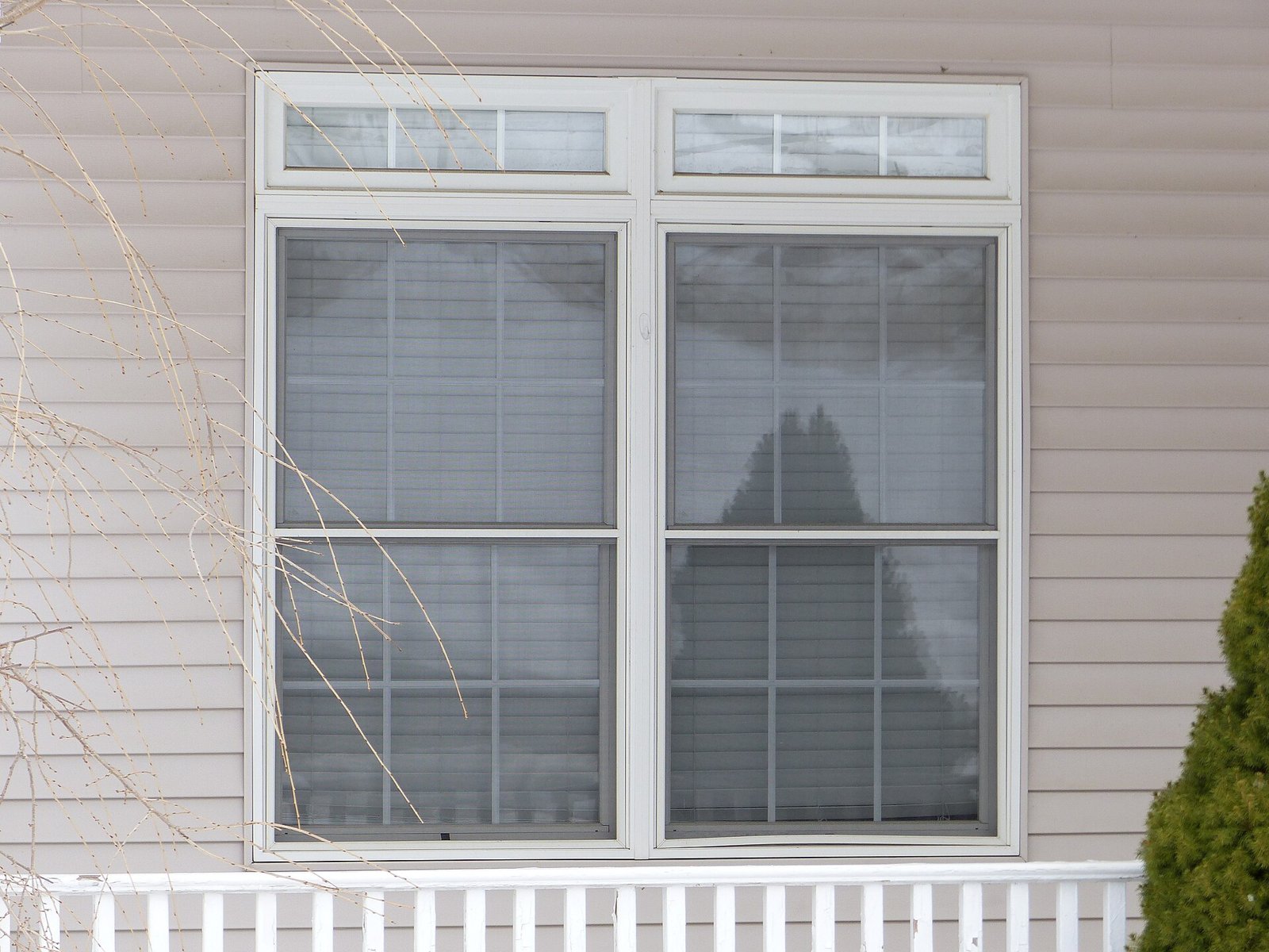 Fenêtre double à cadre blanc sur une façade de maison
